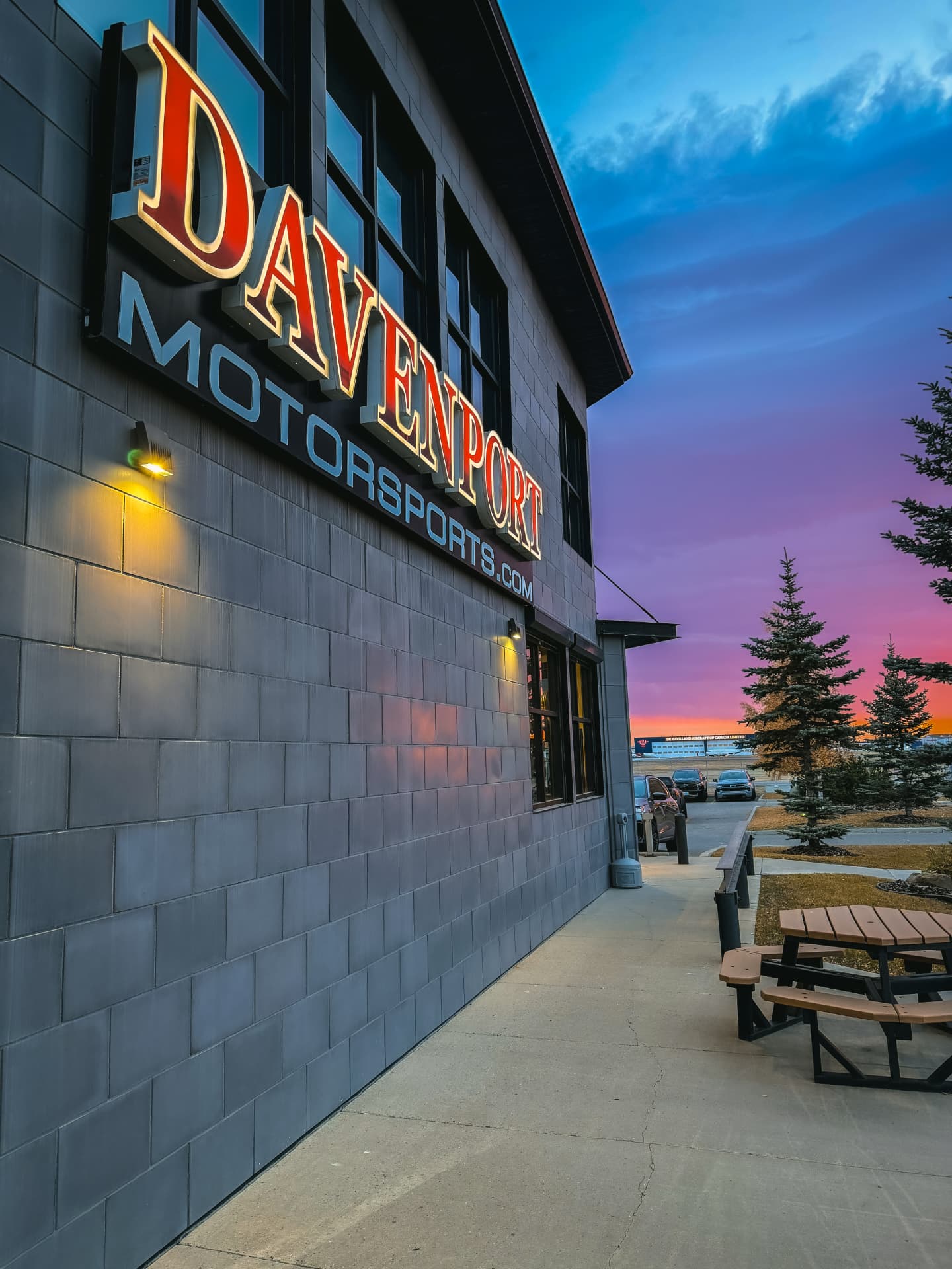 Davenport Motorsports building and illuminated sign at sunset in Calgary